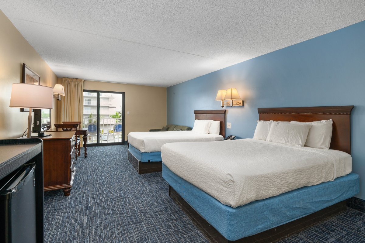 A hotel room with two beds and other furniture.