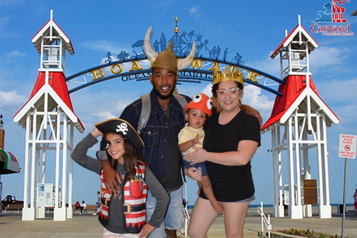 A family photo in front of the OCMD boardwalk sign.