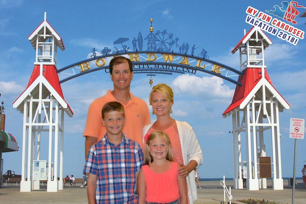 A family posing in front of the entrance to the OCMD boardwalk.