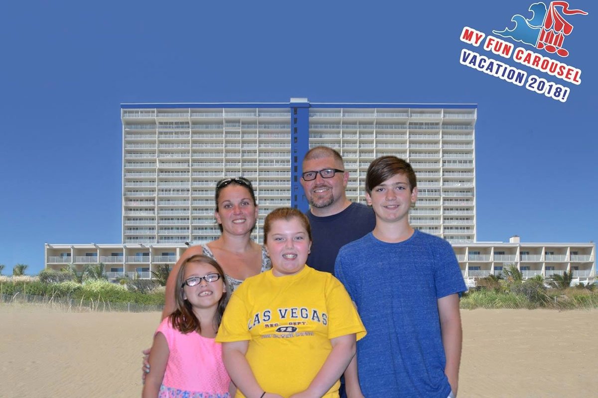 A family posing in front of the Carousel Hotel on the beach.