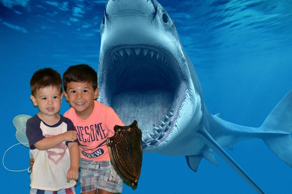 Two young brothers posing by a fake shark.